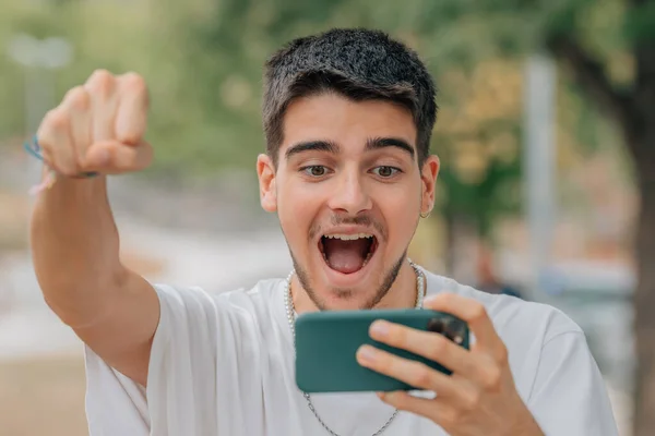 Joven Emocionado Jugando Mirando Teléfono Móvil —  Fotos de Stock