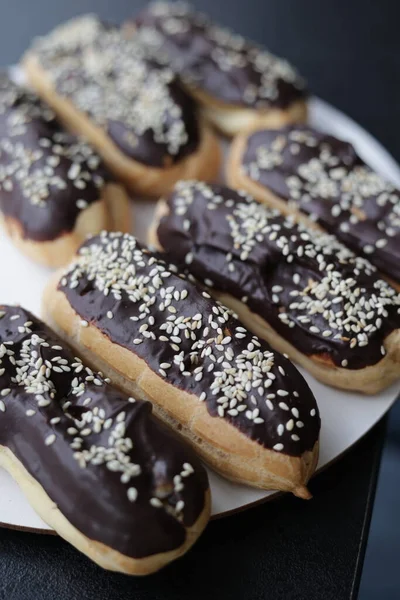 Beautiful eclairs in chocolate on a white plate — Foto Stock