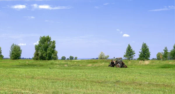 Трактор косит траву на лугу. Хайминг в сельской местности. — стоковое фото
