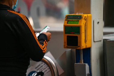 4.10.2021 Milan, İtalya - Milano Merkez Tren İstasyonu. İstasyondaki bir direkte bilet doğrulama cihazı. El, komposteri tren biletini onaylamak için kullanır.