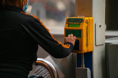 4.10.2021 Milan, İtalya - Milano Merkez Tren İstasyonu. İstasyondaki bir direkte bilet doğrulama cihazı. El, komposteri tren biletini onaylamak için kullanır.