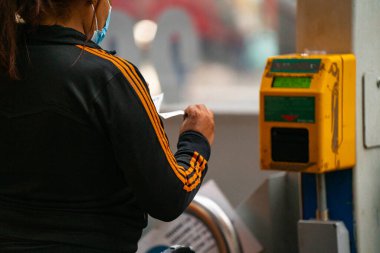 4.10.2021 Milan, İtalya - Milano Merkez Tren İstasyonu. İstasyondaki bir direkte bilet doğrulama cihazı. El, komposteri tren biletini onaylamak için kullanır.