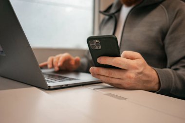 Telefon ve dizüstü bilgisayar, kripto para birimi tüccarı ile çevrimiçi çalış