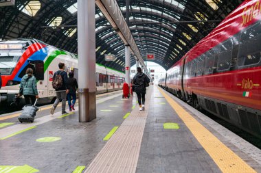 4.10.2021 Milan, İtalya - Milano Merkez Tren İstasyonu. Italo treni istasyonda duruyor, sosyal uzaklığın zemin sembolleri, Avrupa 'daki koronavirüs salgını sırasında tren yolculuğu.