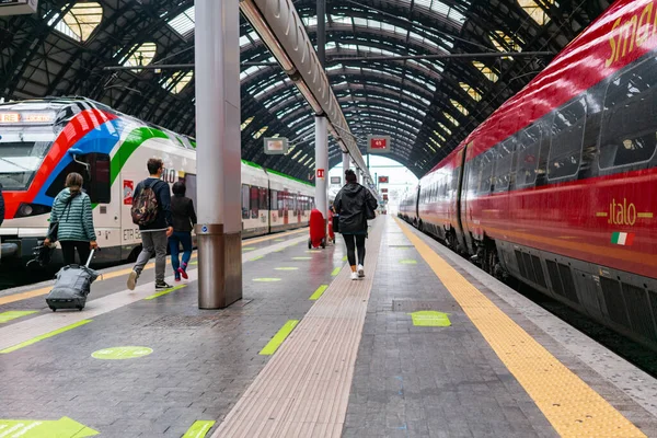 4.10.2021 Milaan, Italië - Station Milano Centrale. Italo trein staat op het station, op de grond symbolen van sociale afstand, trein reizen tijdens de coronavirus pandemie in Europa Stockafbeelding