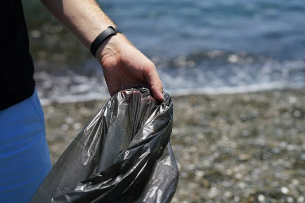 Man Hand Verzamelt Afval Het Strand Houdt Vuilniszak Vast Hoge Stockfoto