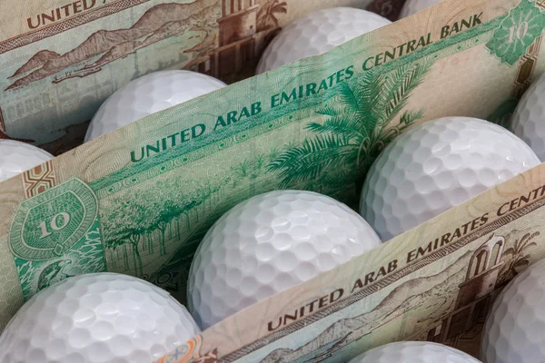 Dirhams and golf balls — Stock Photo, Image