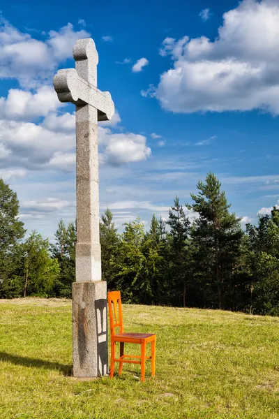 Η πέτρα Σταυρός και αδειάστε ξύλινη καρέκλα — Φωτογραφία Αρχείου