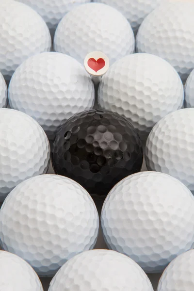 Witte en zwarte golfballen en houten tees — Stockfoto