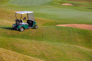 Green golf cart on the empty golf course clipart