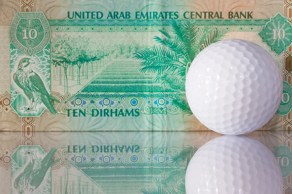 Dirhams og golfbold - Stock-foto