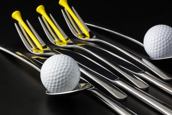 Garfos, colheres e facas e bolas de golfe — Fotografia de Stock