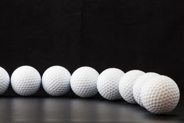 Golfbälle auf schwarzem Hintergrund — Stockfoto