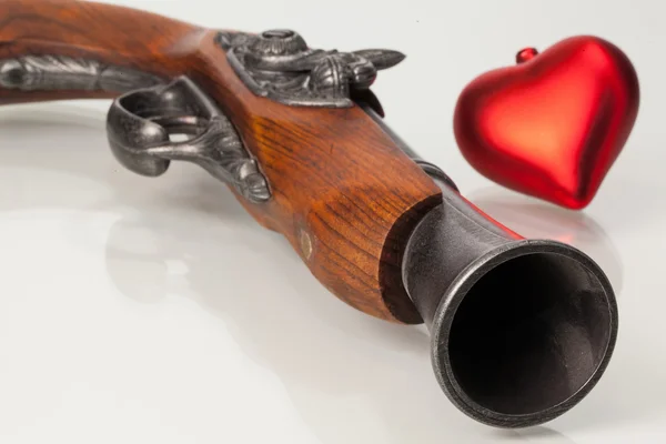 Old gun and red heart — Stock Photo, Image
