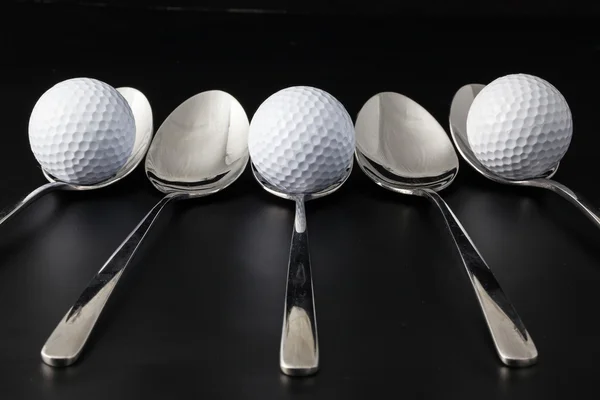 Spoons and golf balls — Stock Photo, Image