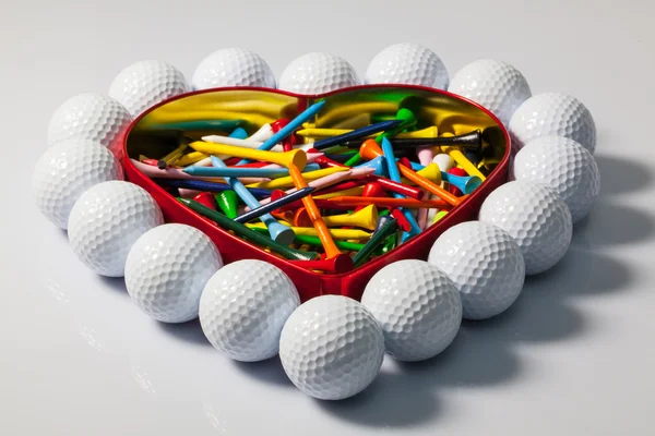 Heart of golf balls and tees — Stock Photo, Image