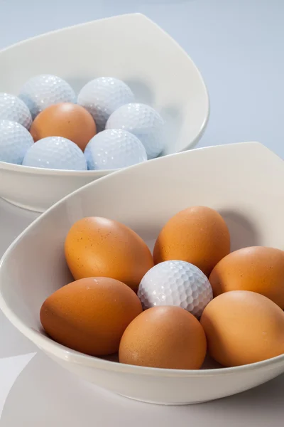 White bowls, easter eggs and golf balls — Stock Photo, Image