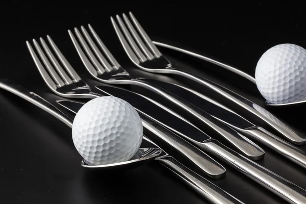 Fourchettes, cuillères, couteaux et balles de golf — Photo