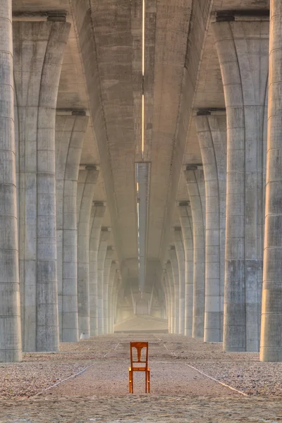 Övergivna stolen under motorvägen bron — Stockfoto