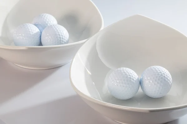 Cuencos de cerámica blanca y pelotas de golf —  Fotos de Stock