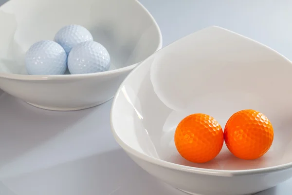 Taças de cerâmica branca e bolas de golfe — Fotografia de Stock