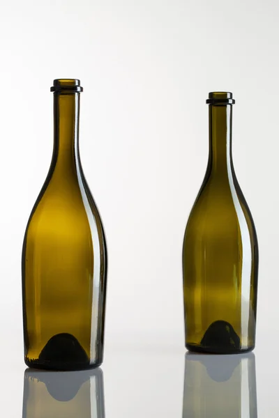 Iki boş şişe şarap cam masa üzerinde — Stok fotoğraf