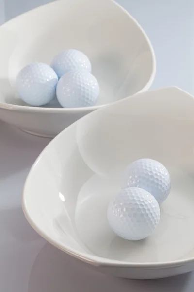 White ceramics bowls and golf balls — Stock Photo, Image