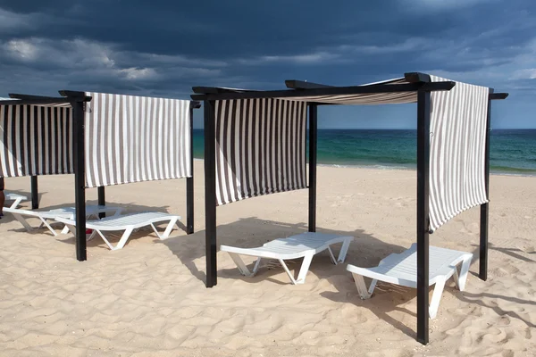 Different parasols and sun loungers on the empty beach on Tavira — Stock Photo, Image