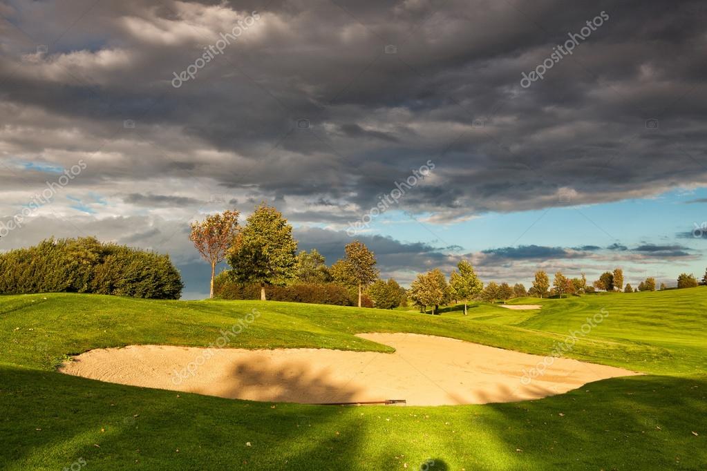 Summer golf course after storm at sunset