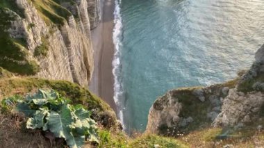 Etretat sahillerinde inanılmaz bir gün batımı. Etretat, Alabaster Sahili 'nin büyüleyici uçurumları ve Normandiya' nın en popüler turistik alanlarından biri olan Etretat 'ın büyüleyici bir kasabasıdır.