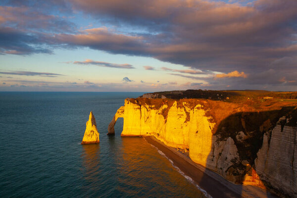 Amazing sunset on the coast in Etretat. Etretat is a charming town famous for the stunning cliffs of Etretat on the Alabaster Coast and one of Normandys most popular tourist sites.