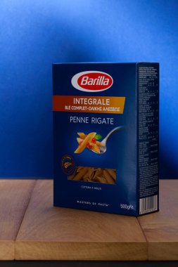 Prag, Çek Cumhuriyeti - 26 Eylül 2021: Tahta masada Barilla Penne Rigate Integrale. Barilla, çok uluslu bir İtalyan gıda şirketi. Dünyanın en büyük makarna üreticisi..