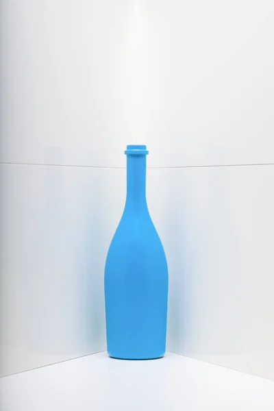 Blauwe Wijnfles Een Witte Hoek — Stockfoto