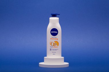 Prag, Çek Cumhuriyeti - 12 Kasım 2021: Nivea Q10 Vücut losyonu Firması mavi arka planda izole edildi. Nivea, Alman Beiersdorf AG şirketine ait..