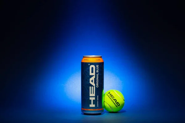 捷克共和国布拉格 2022年5月19日 头顶能量饮料和蓝色背景的黄色网球球 头的能量饮料含有咖啡因和牛磺酸 可以刺激中枢神经系统 — 图库照片