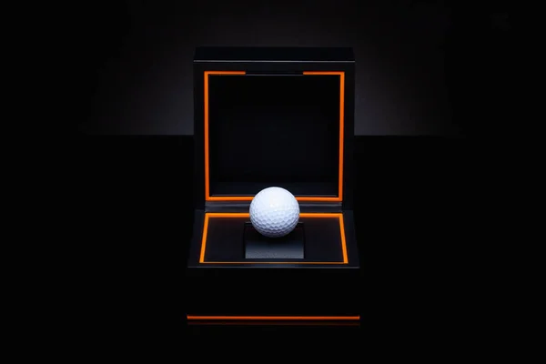 Black box with white golf ball. Velvet case with golf ball. Romantic precious golf gift. Creative image.