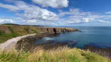 Dunnottar Kalesi 'nin yanındaki dramatik sahilde. Stonehaven 'ın yaklaşık iki mil güneyinde, İskoçya' nın kuzeydoğu kıyısındaki kayalık bir burnun üzerinde yıkılmış bir ortaçağ kalesi..