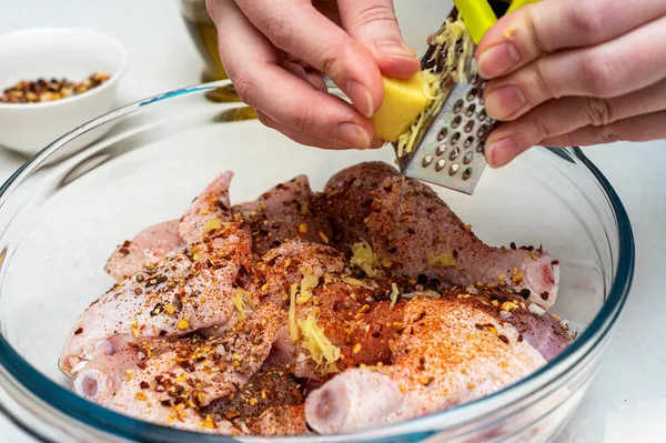 Ajouter le gingembre râpé à la marinade. Mariner le poulet. — Photo