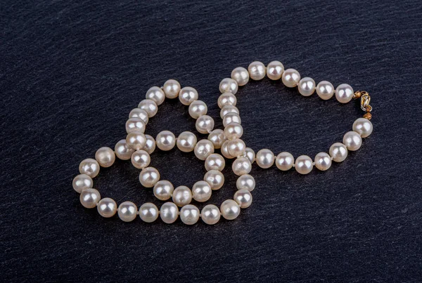 Un collier de perles de perles sur une surface de pierre. — Photo