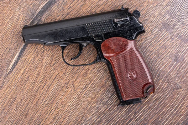 Tahta bir arka planda makarov sisteminin tabancasının üst görüntüsü. Rus polisinin ana silahı..