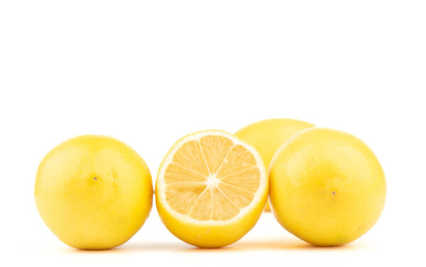 Half lemon and whole lemons on a white background. Copy space.