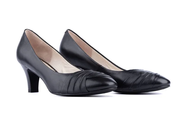 Vrouwen zwarte schoenen bevinden zich naast elkaar op een witte achtergrond. — Stockfoto