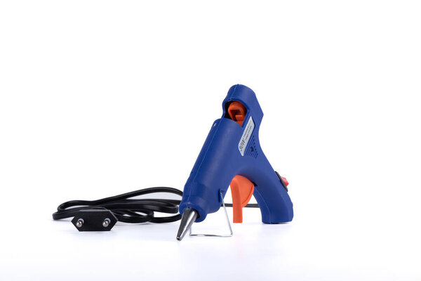 Glue gun with electric cord on a white background. Copy space.