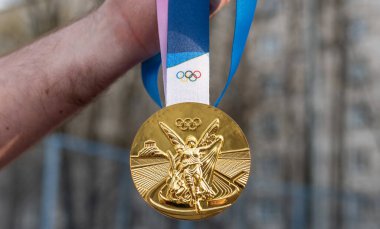 April 17, 2021 Beijing, China. Olympic gold medal in the hand of an athlete. clipart