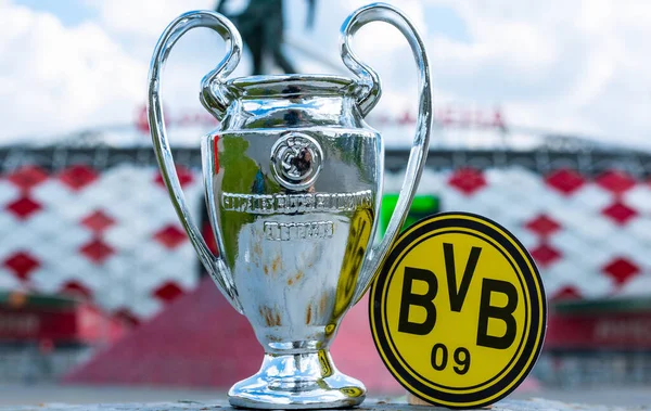 14 Haziran 2021 Dortmund, Almanya. Borussia Dortmund futbol kulübü ve UEFA Şampiyonlar Ligi Kupası 'nın amblemi modern bir stadyumun arka planına karşıdır..