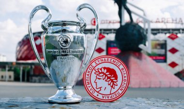 14 Haziran 2021 Atina, Yunanistan. Futbol kulübü Olympiacos Pire ve UEFA Şampiyonlar Ligi Kupası 'nın amblemi modern stadyumun arka planına karşıdır..