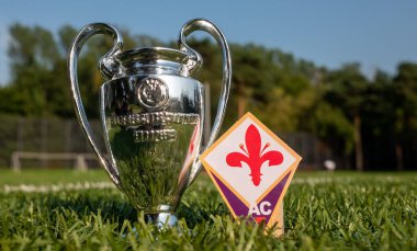 30 Ağustos 2021, Floransa, İtalya. ACF Fiorentina futbol kulübü ve yeşil çimenli UEFA Şampiyonlar Ligi Kupası amblemi..