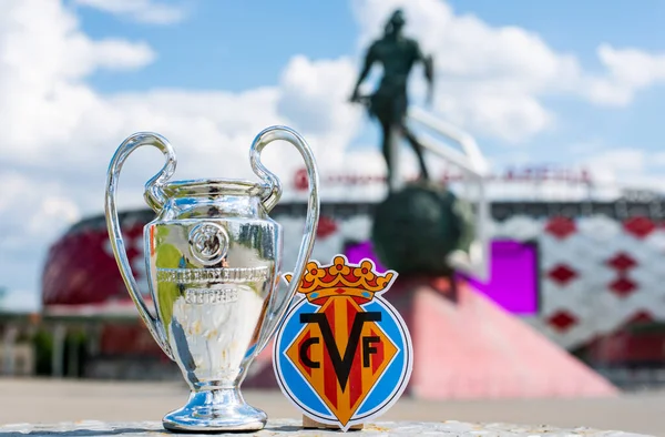 14 Haziran 2021 Villarreal, İspanya. Villarreal CF futbol kulübü ve UEFA Şampiyonlar Ligi Kupası 'nın amblemi modern bir stadyumun arka planına karşıdır..