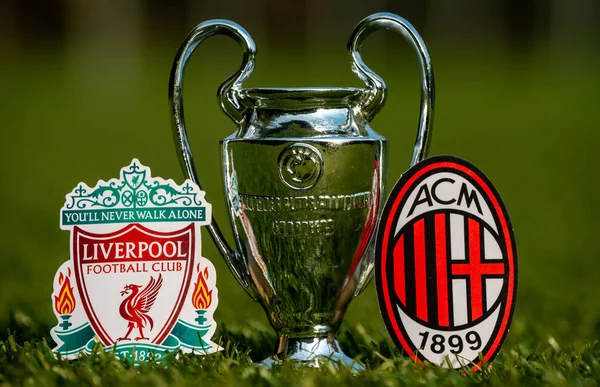 stock image August 27, 2021 Liverpool, UK.  Football Club Emblems Liverpool F.C.and A.C. Milan and the UEFA Champions League Cup on the green turf of the stadium.