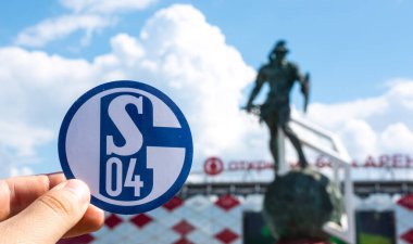 14 Haziran 2021, Gelsenkirchen, Almanya. Futbol kulübü FC Schalke 04 'ün amblemi modern stadyumun arka planına karşıdır..
